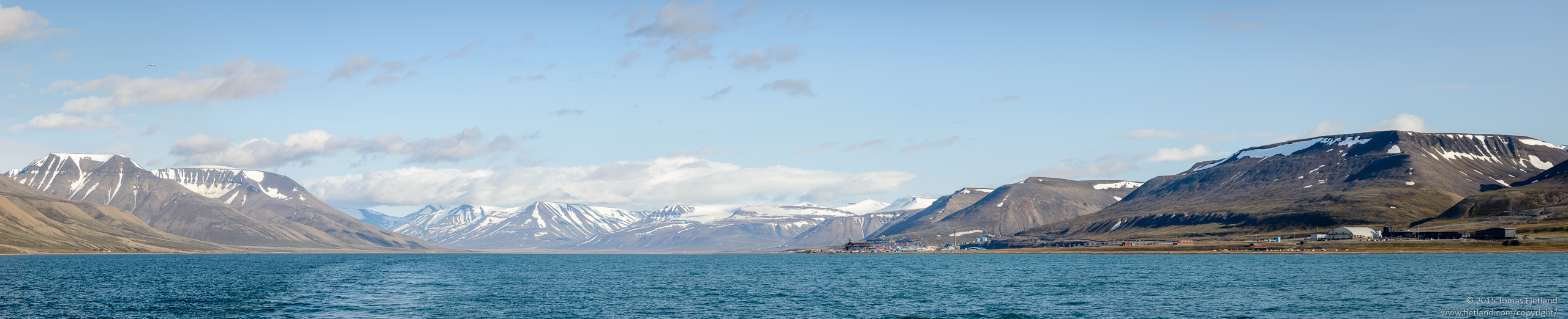 Panorama view of Adventbukta with Longyearbyen just to the right of the middle and Longyearbyen airport in the far right of the frame
